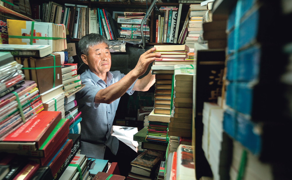 정병호 씨가 서울 평화시장에서 40년 동안 운영해 온 헌책방 서문서점에서 책들을 살펴보고 있다. Jeong Byung-ho kiểm tra sách tại tiệm sách Seomun, cửa hàng sách cũ mà ông đã mở cửa trong 40 năm qua ở khu chợ Pyeonghwa, ngay trung tâm thành phố Seoul.