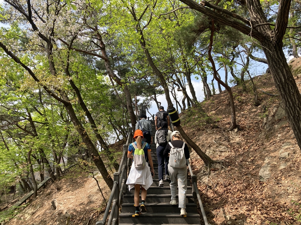 ▲ '서울 도심 등산관광센터 북악산'에서 운영하는 올해 첫 체험 프로그램 참가자들이 12일 북악산 계단을 오르고 있다. Những người tham gia chương trình đầu tiên của năm nay do chi nhánh Bugaksan của Trung tâm du lịch leo núi Seoul (Seoul Hiking Tourism Center) thực hiện đã leo núi Bukgaksan vào ngày 12/4/2024. (Ảnh: Charles Audouin / Korea.net - 샤를 오두앙 기자 caudouin@korea.kr)