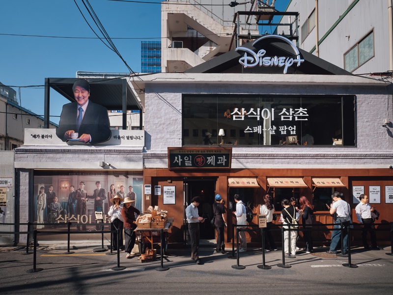 디즈니 플러스(Disney+)가 자사 오리지널 시리즈 < 삼식이 삼촌(Uncle Samsik) > 공개를 앞두고 2024년 5월 연무장길에서 진행한 팝업 스토어 전경. 빵집과 사무실 등 작품 속 배경을 그대로 구현했다. Quang cảnh cửa hàng pop-up được Disney+ tổ chức trên đường Yeonmujang-gil vào tháng 5 năm 2024 trước khi phát hành loạt phim gốc “Chú Samsik” (Uncle Samsik). Bối cảnh của phim, bao gồm một tiệm bánh và một văn phòng, được tái hiện chính xác.