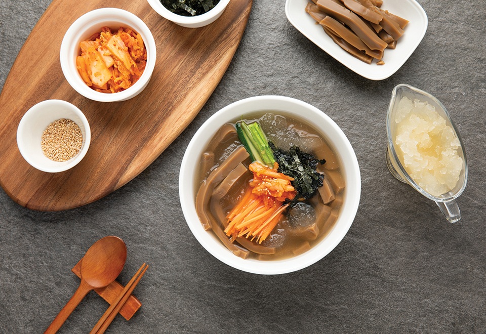 Dotorimuksabal chilled acorn jelly soup with long strips of dotorimuk acorn jelly kimchi cucumber and seaweed