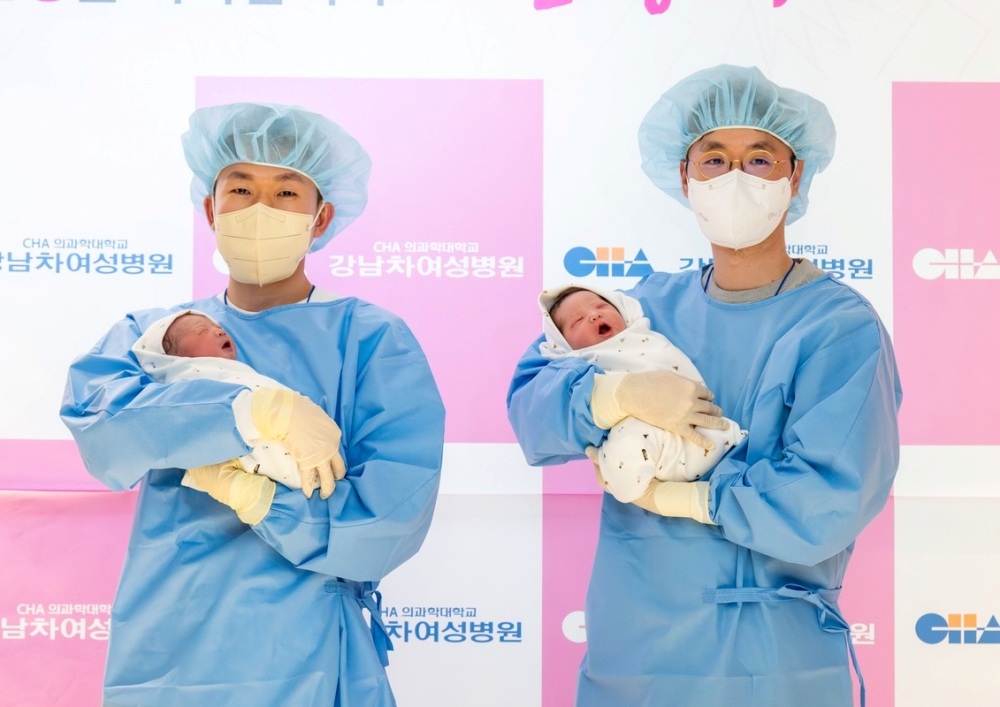 ▲ 올해 1월 출생아 수가 2만 6916명을 기록했다. 사진은 서울 강남구 강남차여성병원에서 태어난 2026년 새해 첫아기 두 명이 아빠 품에 안겨 있다. Số trẻ sinh trong tháng 1 năm nay đạt 26.916 ca. Trong ảnh là hai em bé đầu tiên chào đời trong năm 2026 tại Bệnh viện Phụ sản CHA Gangnam, quận Gangnam, Seoul, đang được bố ẵm. (Ảnh: Bệnh viện Phụ sản CHA Gangnam trực thuộc đai học Y khoa CHA - 차 의과학대학교 강남차여성병원)